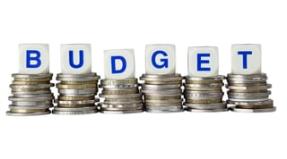 Budgeting 101: How to Set Up a Workable Plan Budget letters on coin stacks