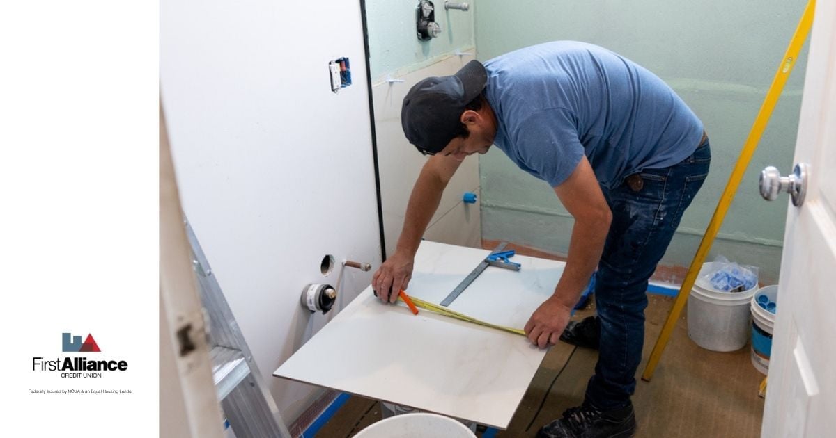 homeowner remodeling bathroom with tile installation