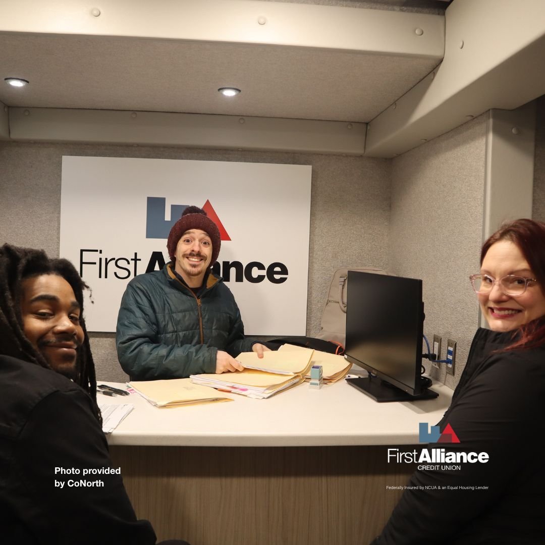 3 people signing paperwork inside First Alliance Mobile Branch
