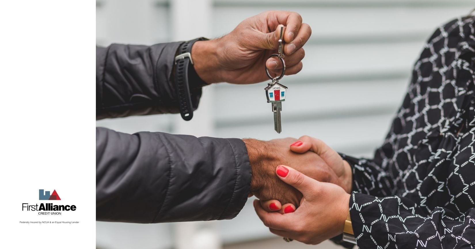 shaking hands and exchanging a key ring with a house symbol on it
