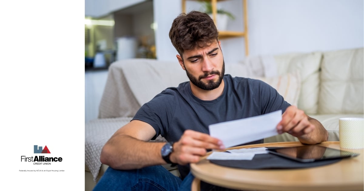 A young bearded with a worried expression, he's reviewing his first credit card statement