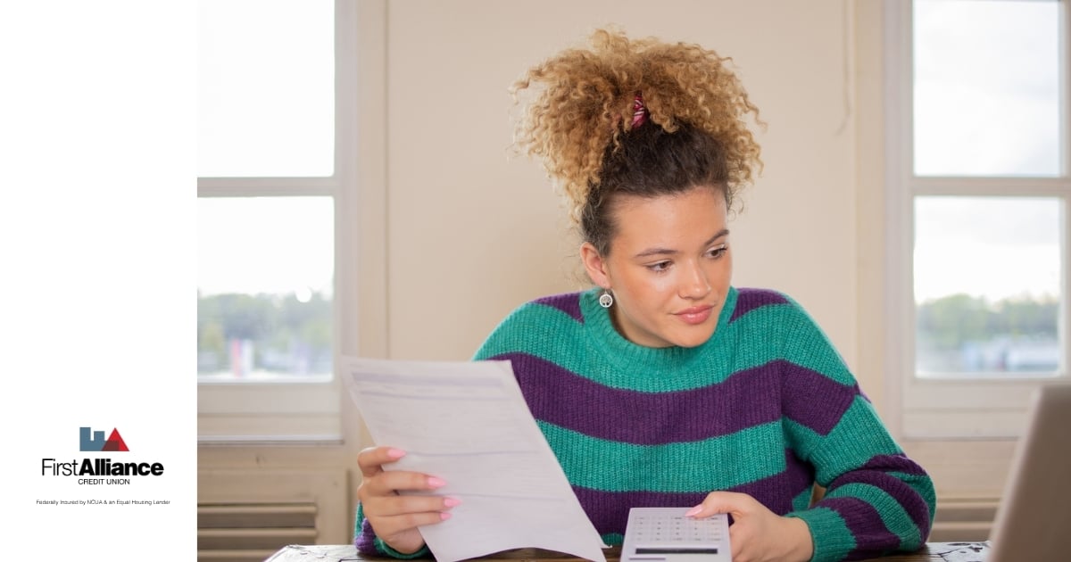 woman in a sweater reviewing her budget