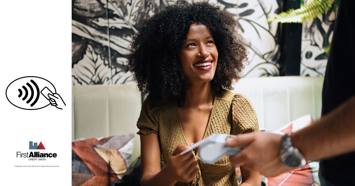 woman smiling using tap to pay credit card