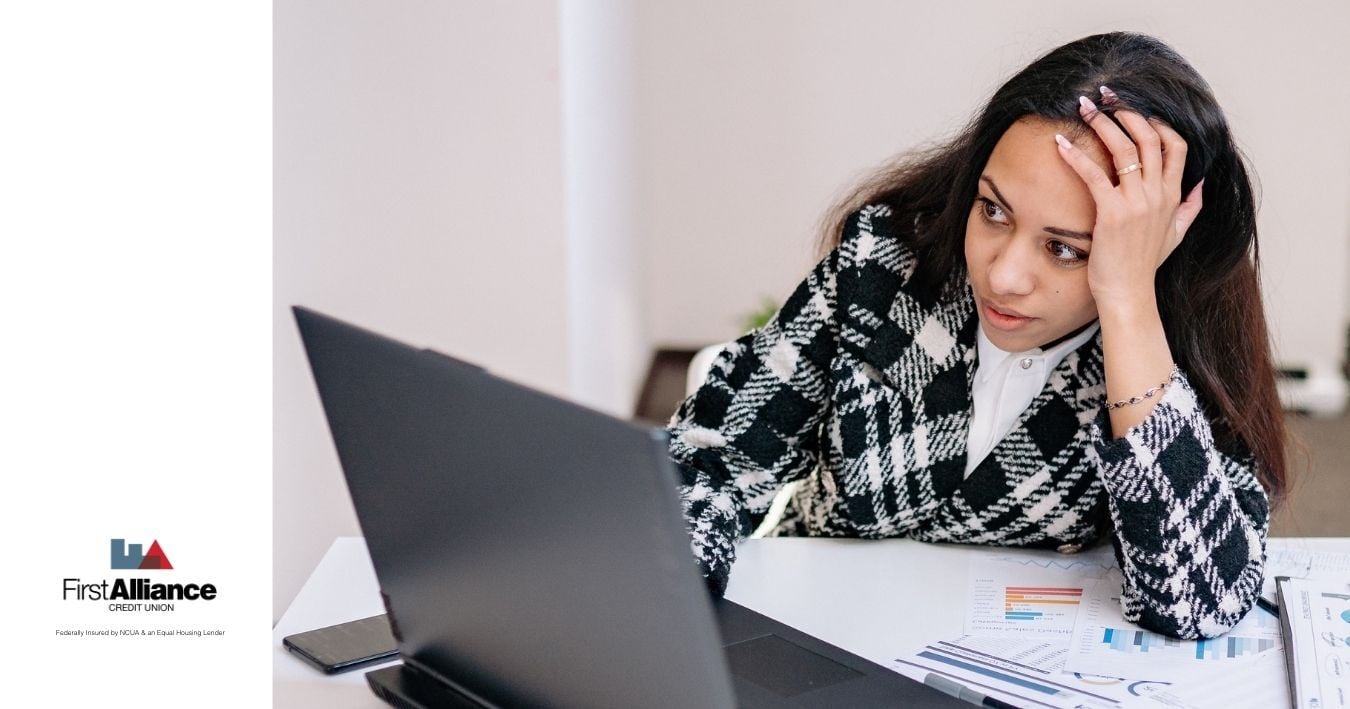 woman looking at laptop with concerned expression