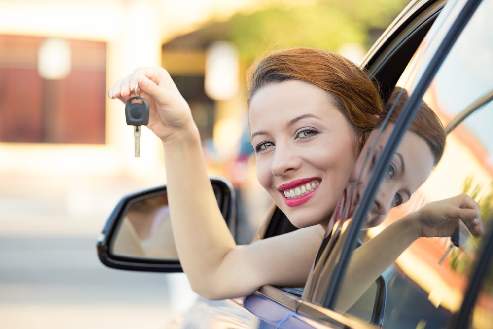 Closeup portrait happy, smiling, young attractive woman, buyer sitting in her new blue car showing keys isolated outside dealer, dealership lot, office. Personal transportation, auto purchase concept-1