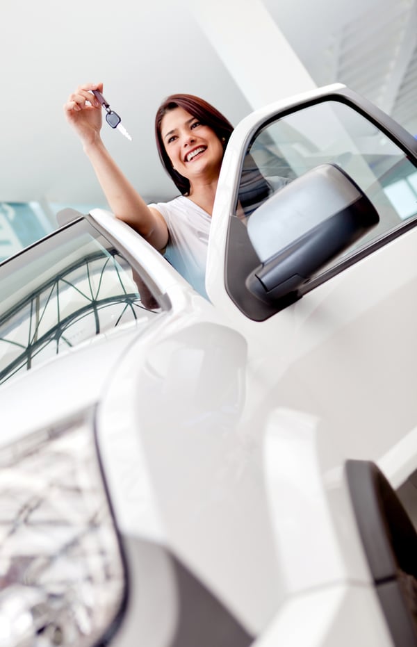 happy young woman buying a new or used vehicle