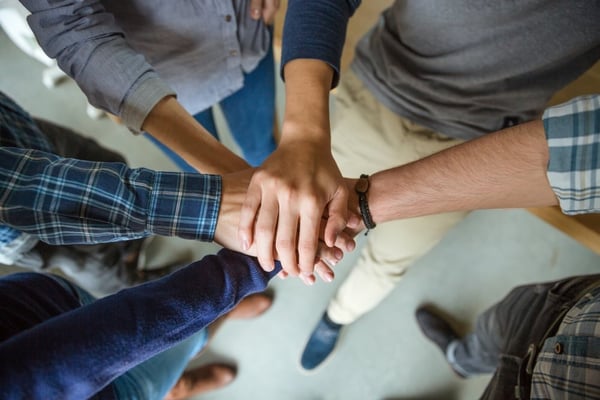 Hands in a circle to represent credit union philanthropy 