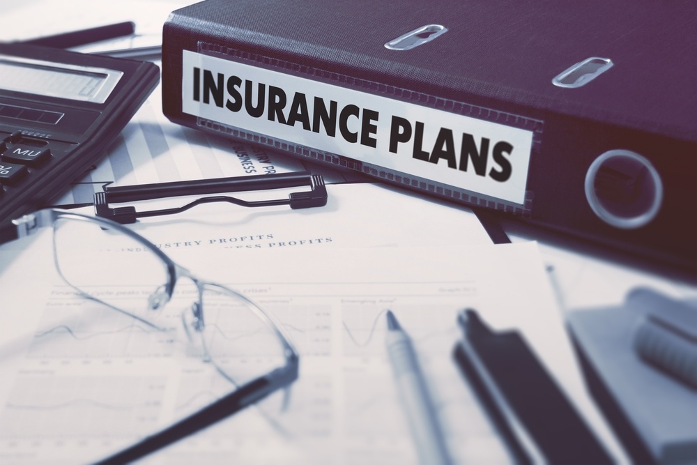 Burgundy binder with the label Insurance Plan for trustage insurance plans at first alliance credit union