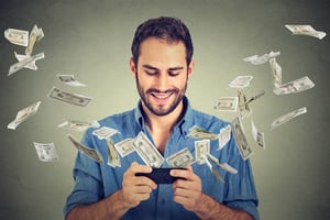 Man watching money fly from his phone