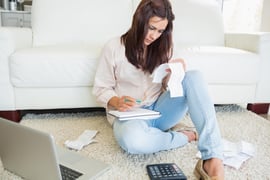 Woman checking bills on the carpet of living room