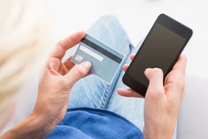 Woman doing online shopping with her mobile phone on white background