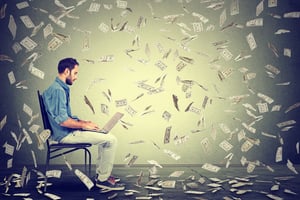 Young man with laptop and money in the air