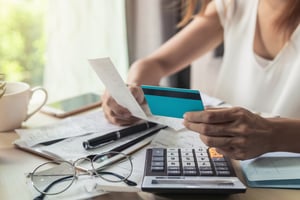 Woman paying off debts and holding credit card