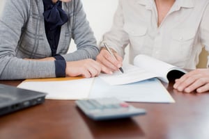 Torso shot of one person explaining finances to someone else | First Alliance Credit Union