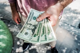 Person's hand holding cash