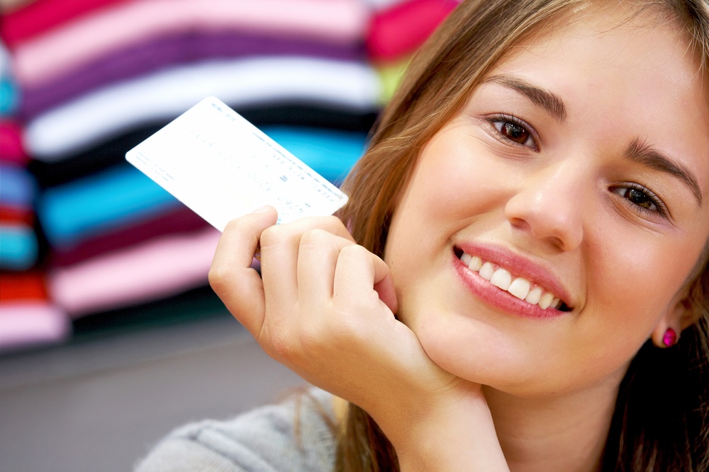 Woman holding a credit card | First Alliance Credit Union