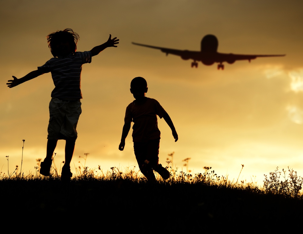 Active two kids jumping while the airplane landing in air.jpeg