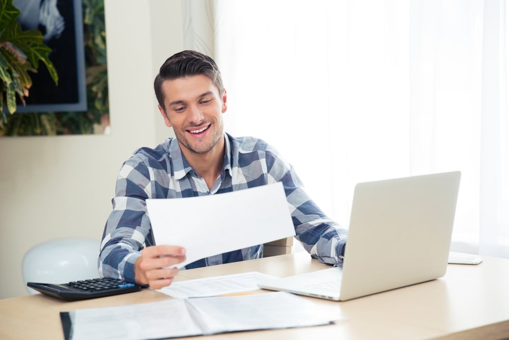 Man smiling at paperwork