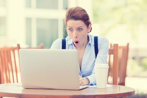 Surprised woman looking at her laptop | First Alliance Credit Union