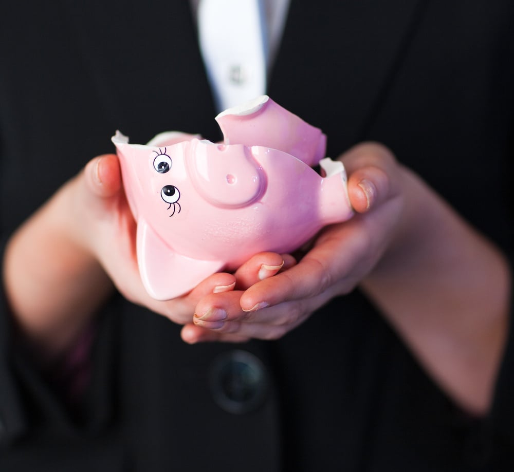 Young Business woman holding a broken piggy bank