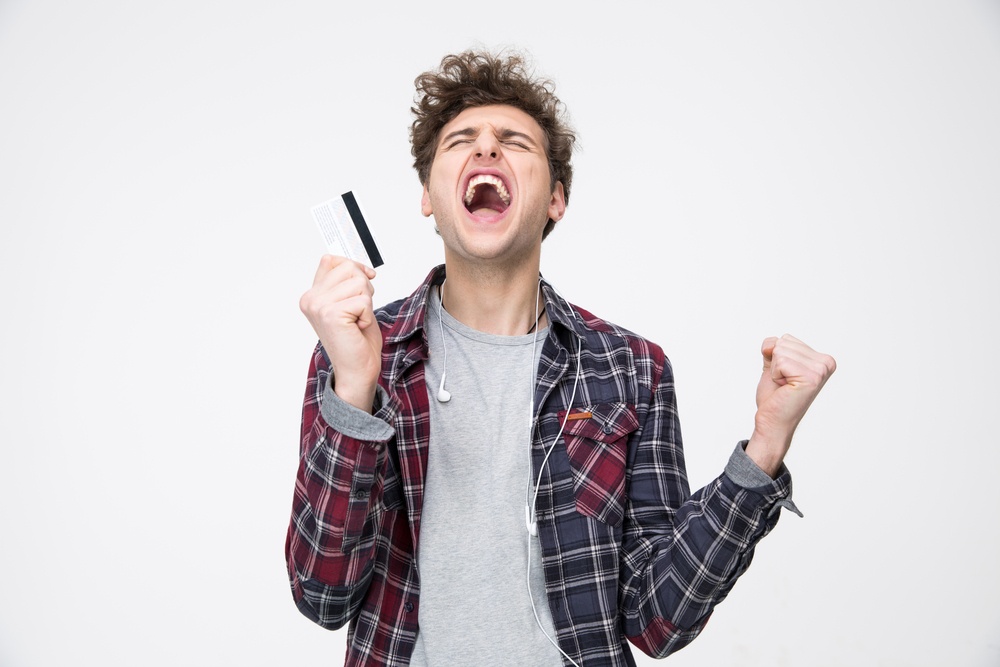 Young casual man standing with credit card and shouting-1