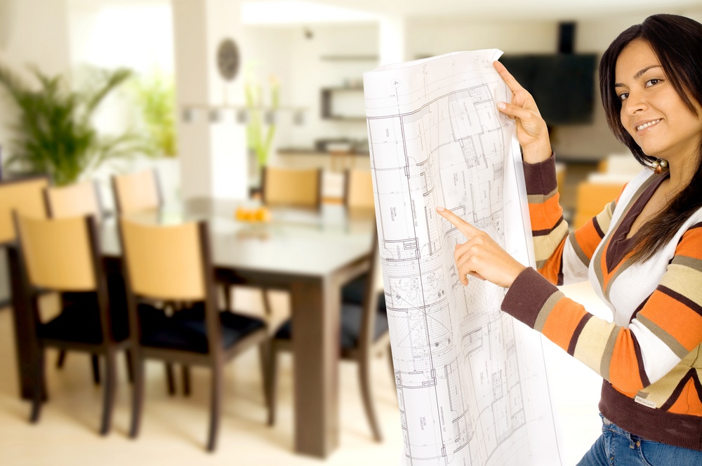 girl holding blue prints while smiling at the camera - home interior