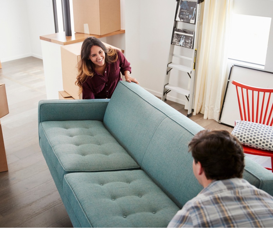 Couple moving a new sofa into their house.