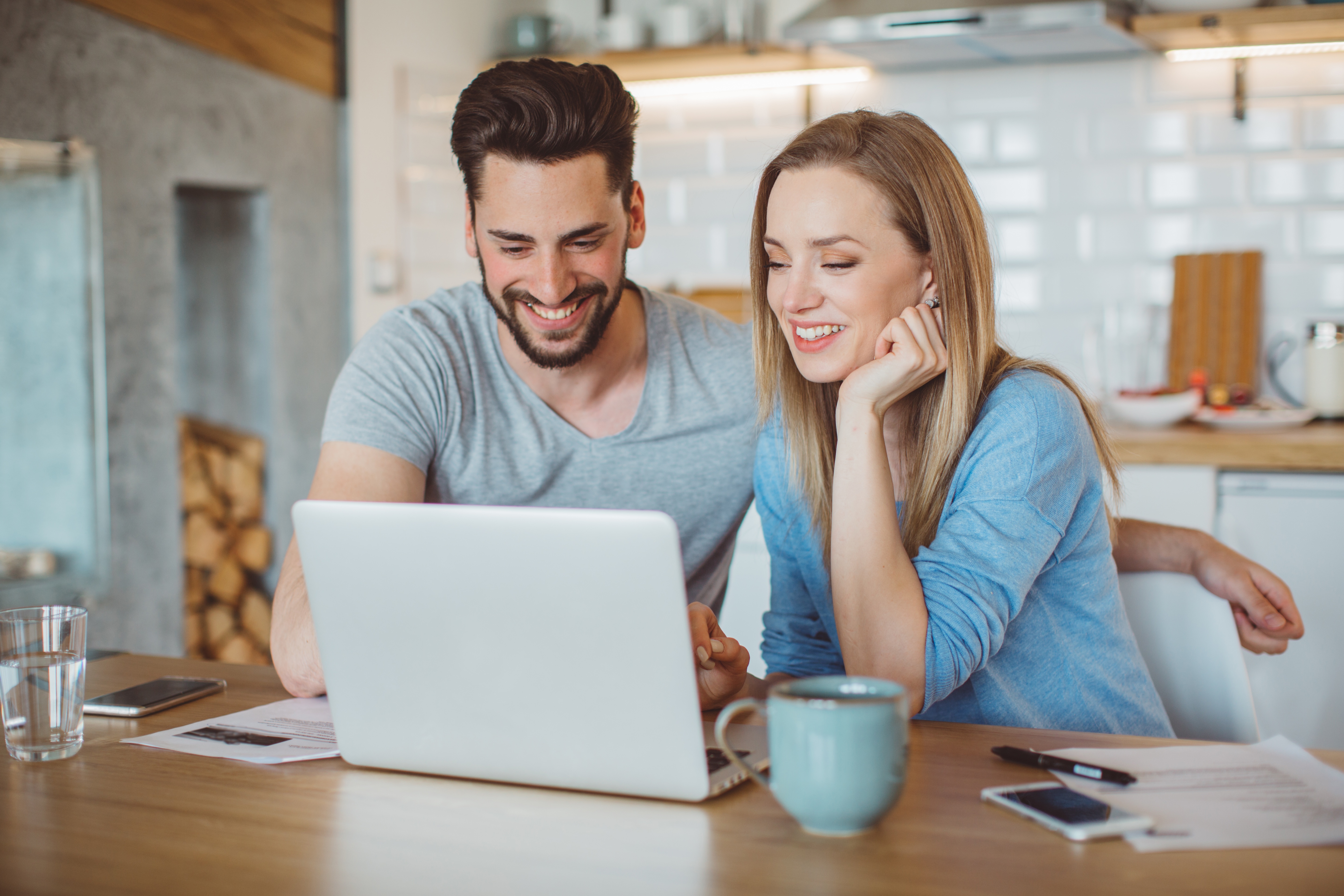 happy couple looking at computer in kitchen.jpg