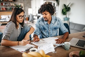 Multiracial couple creating a budget together | First Alliance Credit Union