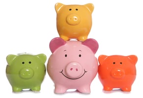 Several multicolored piggy banks with the central piggy bank smiling | First Alliance Credit Union