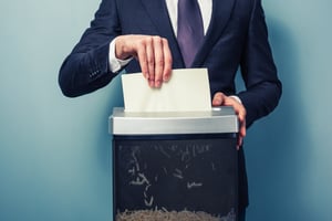Man in suit shredding documents