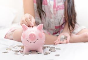 Girl and Piggy Bank | First Alliance Credit Union