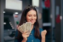 Woman with money | First Alliance Credit Union