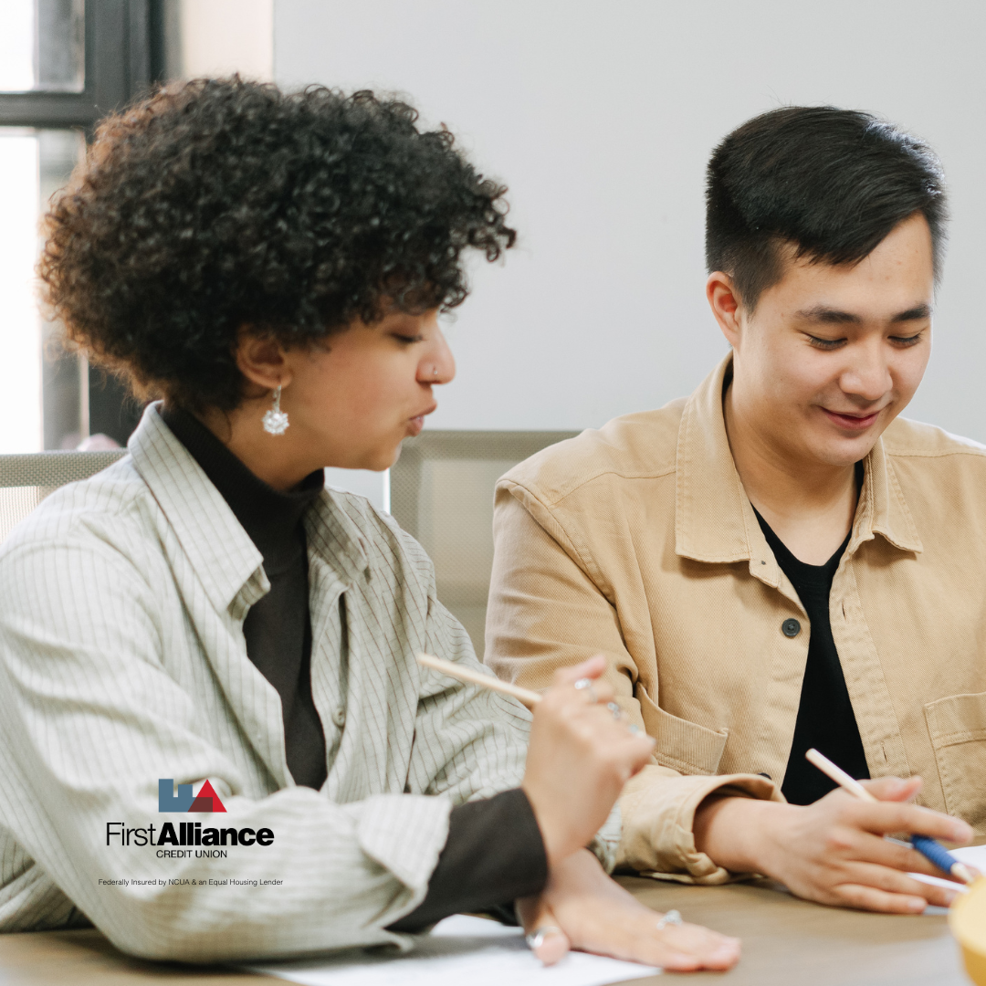 two people looking at paperwork with pen in hand